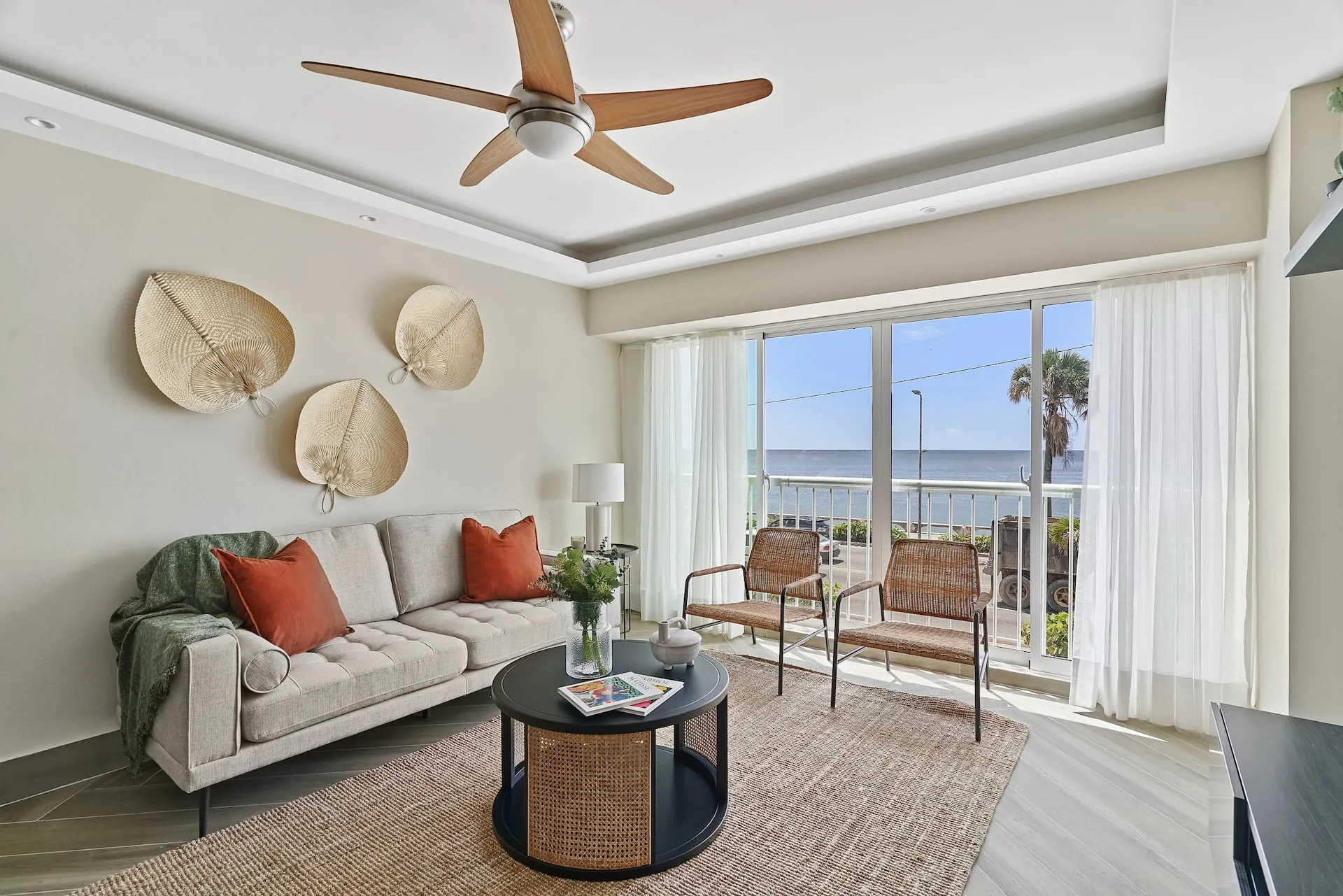 One-bedroom apartment living room with a sofa, ceiling fan and sea view