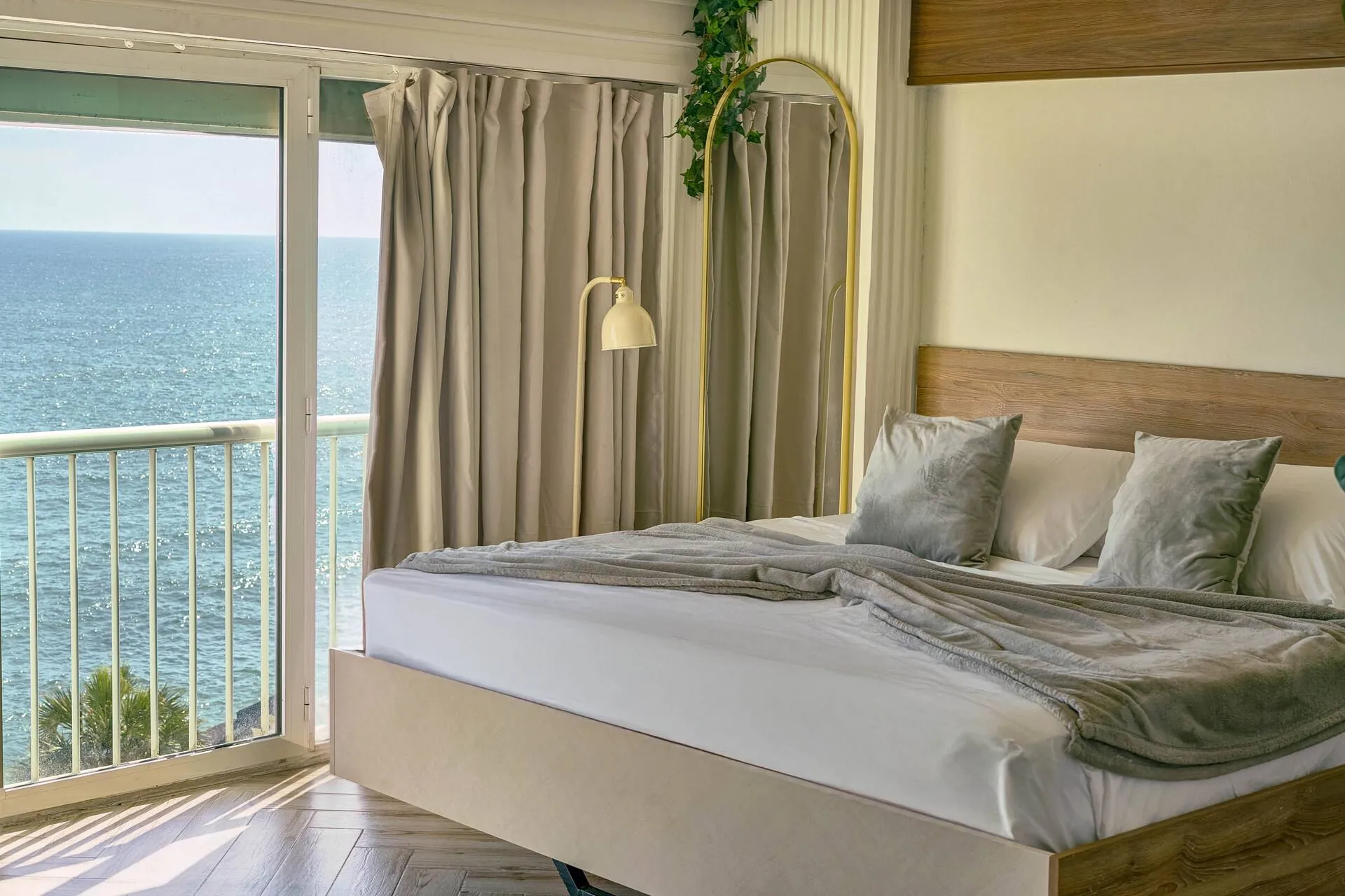 King bed beside balcony doors and the sea