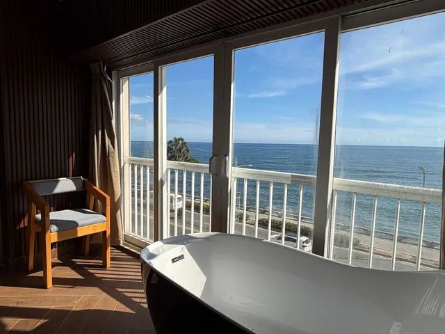 Black bathtub by tall windows over the Malecón