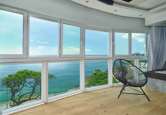 Corner windows with a lounge chair looking over the sea