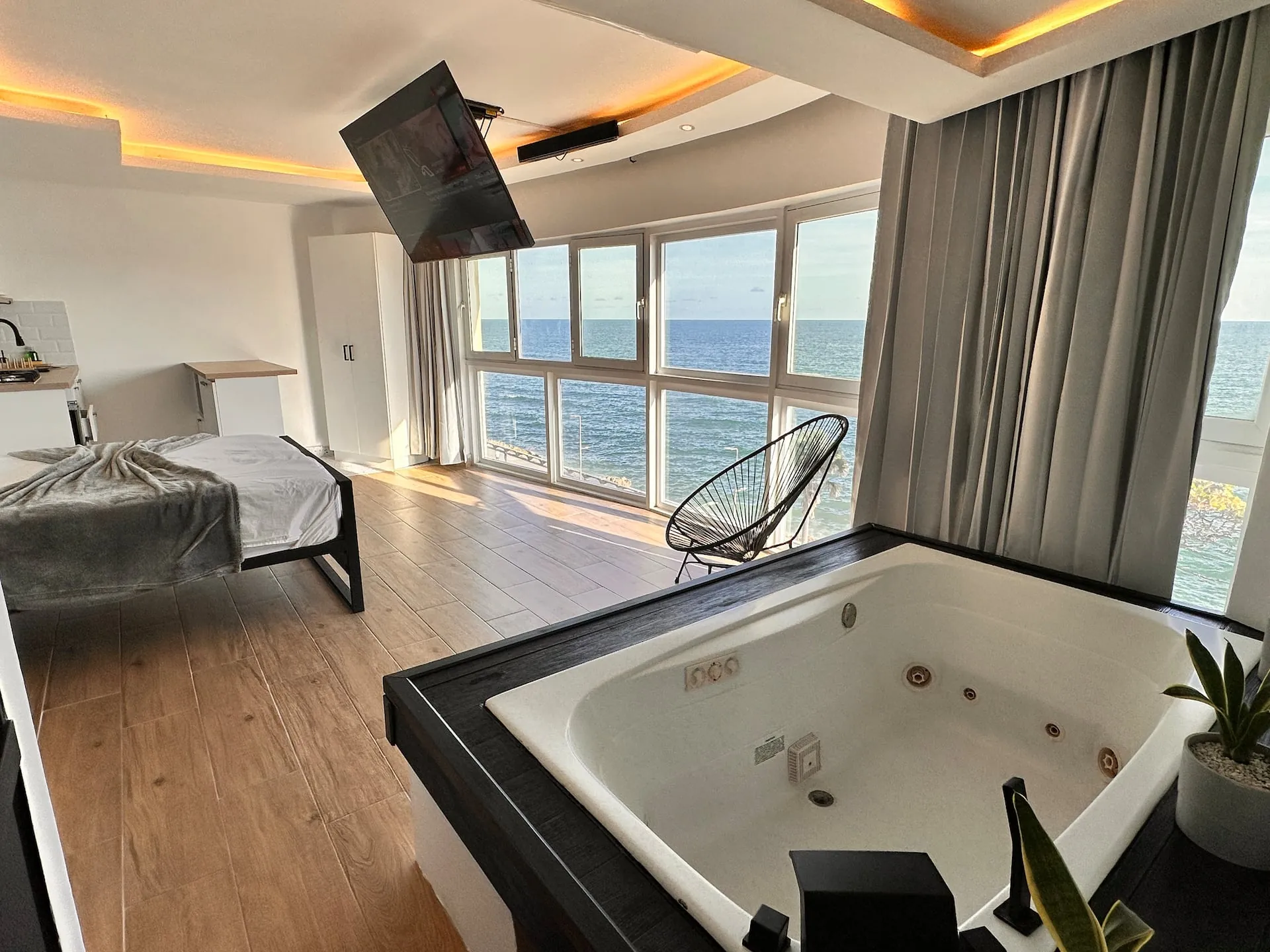 Built-in jacuzzi beside windows on the sea in a bright studio