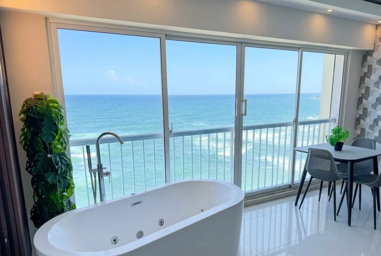 Jetted tub in front of glass doors and the Caribbean