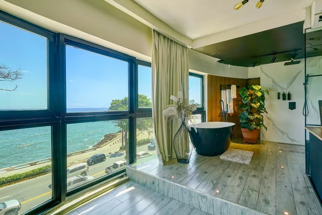 Loft bath platform with a tub and a view along the coast