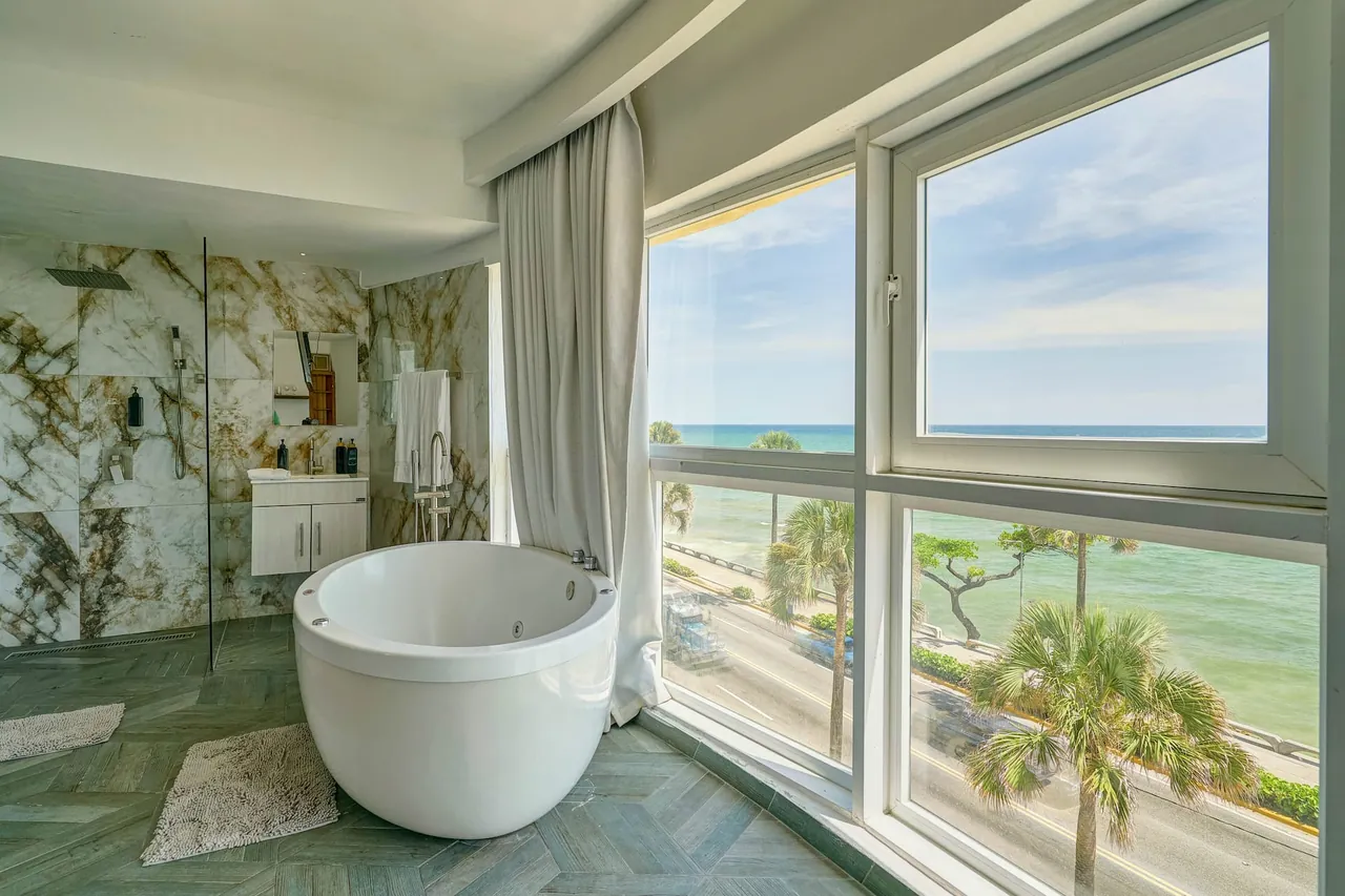 Loft bath area with a round tub and palms outside