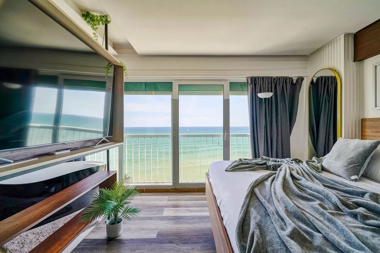 Penthouse bedroom with a wall of windows on the sea