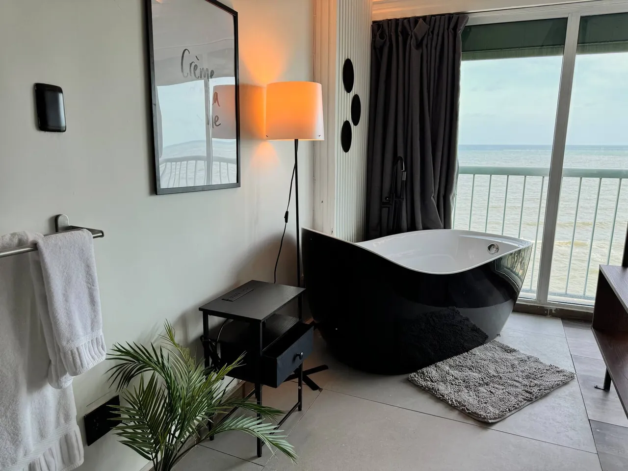 Black bathtub and floor lamp in the penthouse