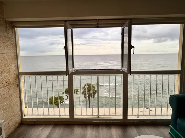 Sliding doors opening onto the sea and palm tops