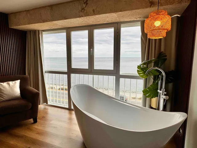 Slipper bathtub in front of sea-view windows