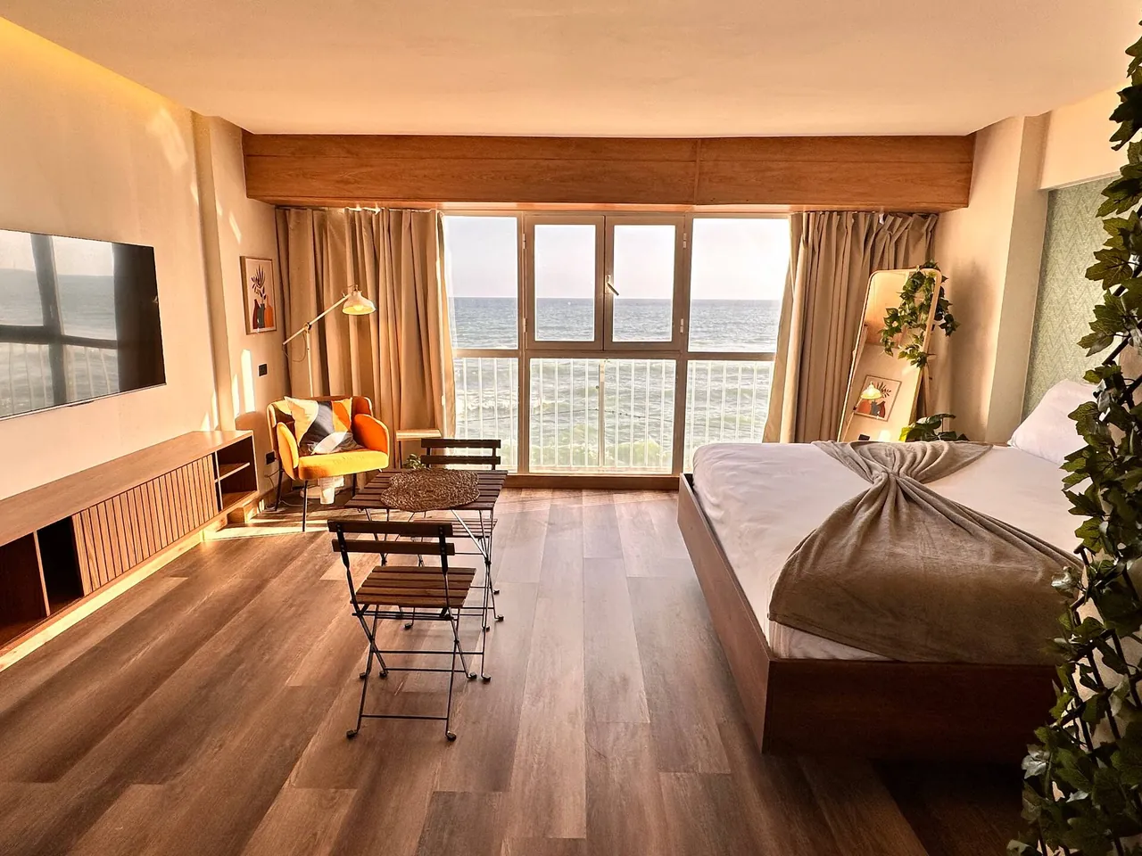 Studio with wood floors, a dining set and windows on the sea