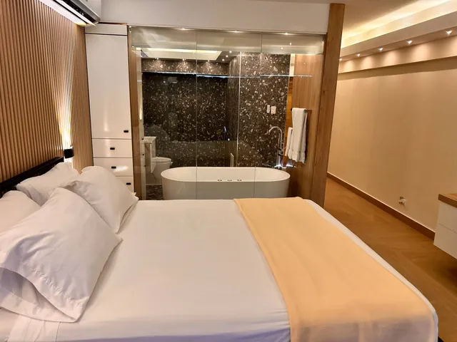 Suite with a king bed and a tub set in a stone-clad bath area