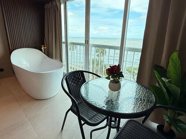 Bathtub and a glass bistro table set by the window