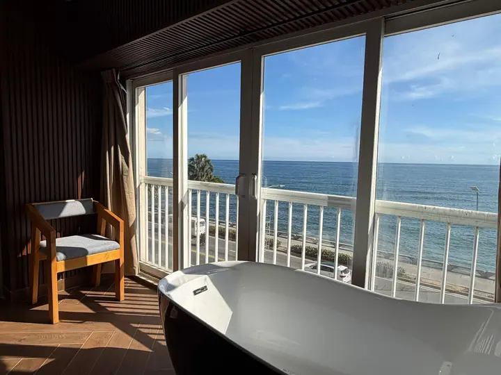 Black bathtub by tall windows over the Malecón