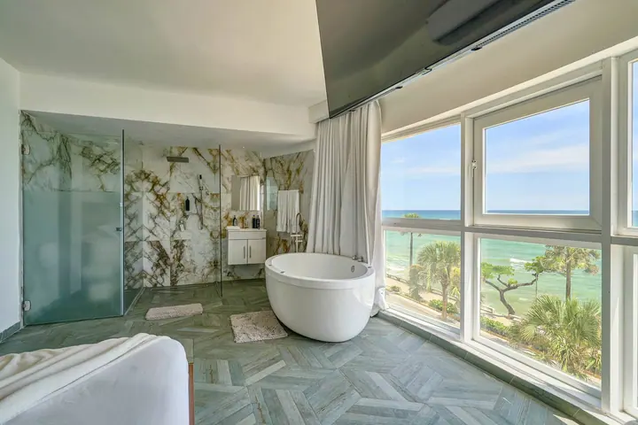Round jetted tub beside windows on the seafront avenue