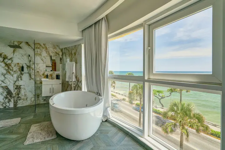 Loft bath area with a round tub and palms outside