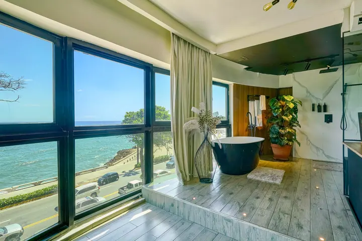 Loft bath platform with a tub and a view along the coast