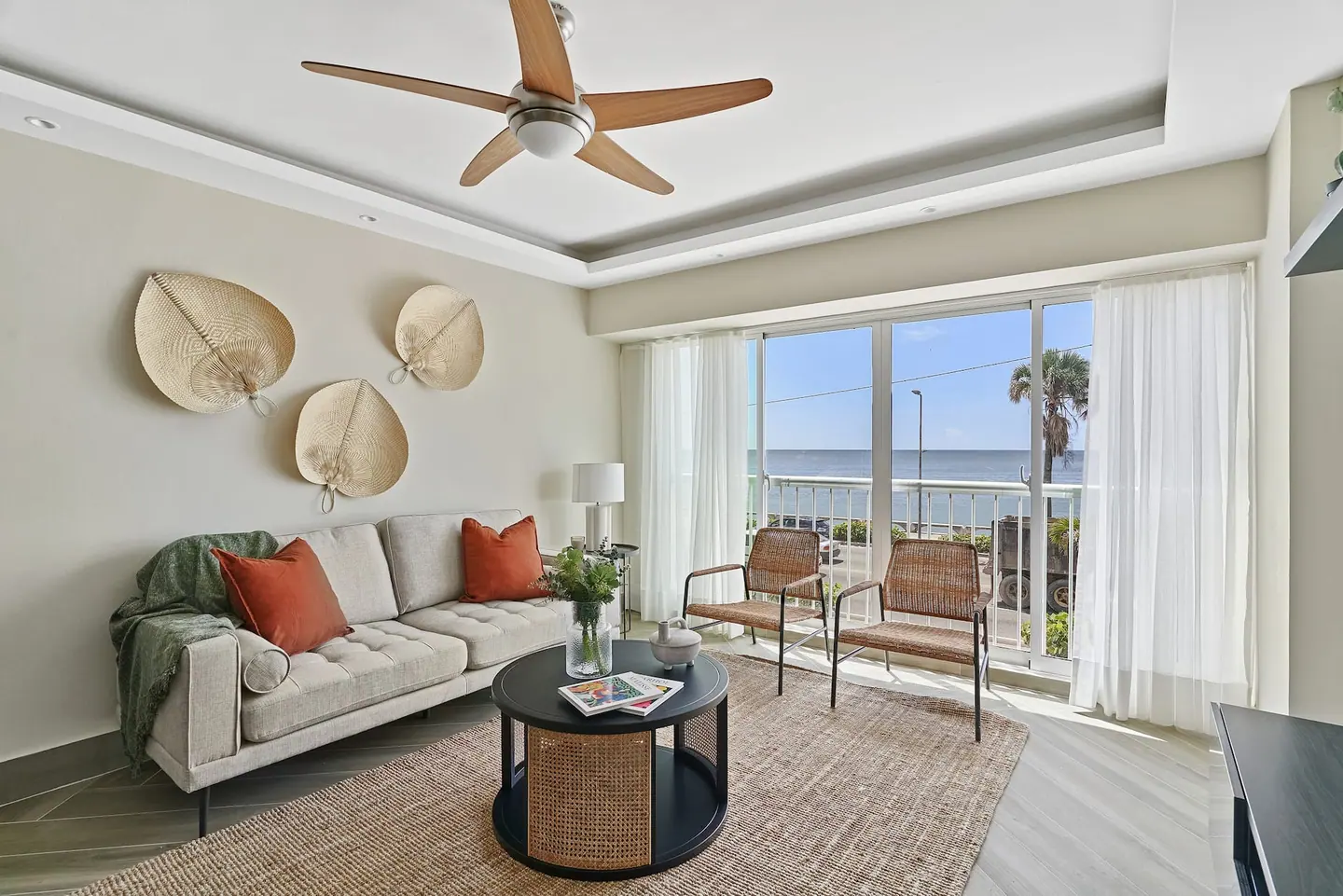 One-bedroom apartment living room with a sofa, ceiling fan and sea view